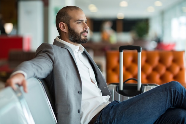 Foto gratuita hombre de negocios pensativo sentado en una silla en la sala de espera