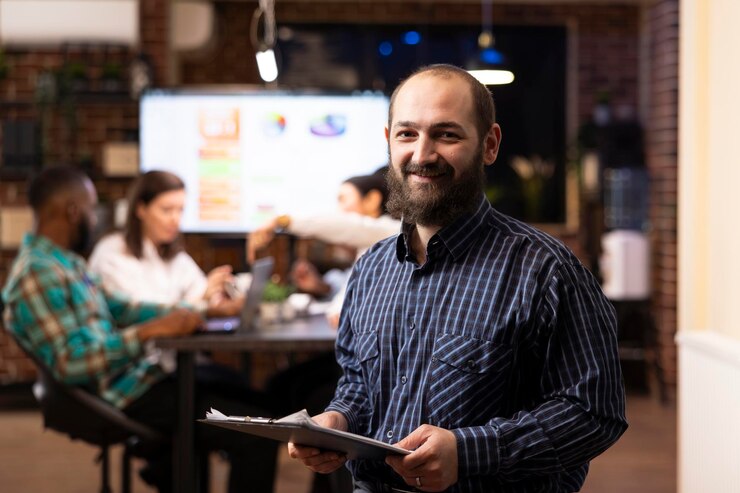 Foto gratuito un hombre de negocios con un portapapeles sonriendo a la cámara.