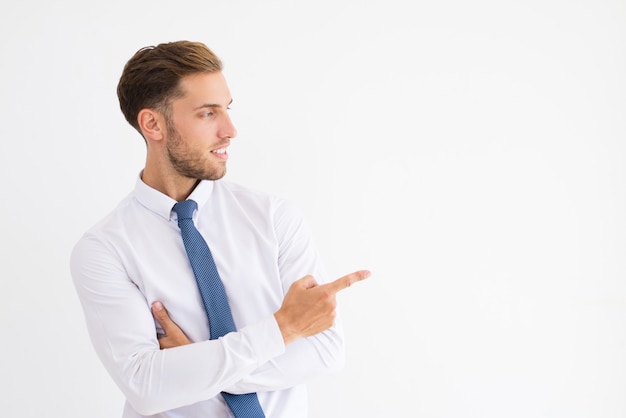 Foto gratuita hombre de negocios positivo que señala el dedo a un lado