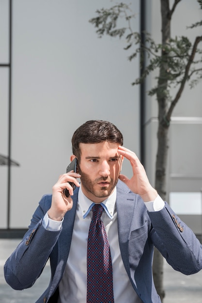 Hombre de negocios preocupado hablando por teléfono