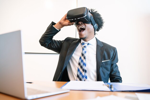 Hombre de negocios profesional con casco de realidad virtual en la oficina moderna.
