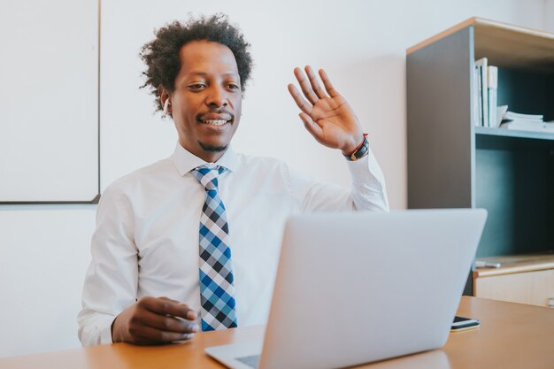 Hombre de negocios profesional en una reunión virtual en videollamada con portátil en la oficina. Concepto de negocio.