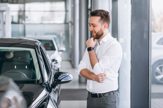 Hombre de negocios que compra un coche en una sala de exposición