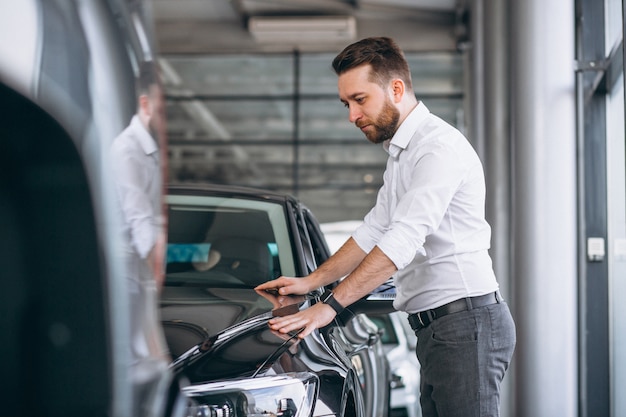 Hombre de negocios que compra un coche en una sala de exposición