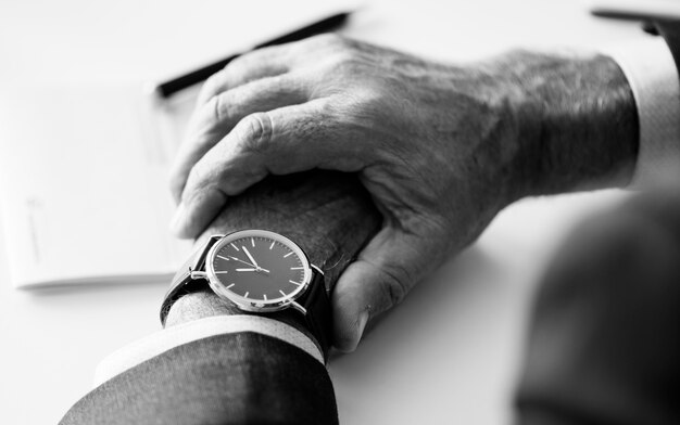 Hombre de negocios que controla tiempo en reloj de mano