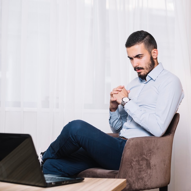 Hombre de negocios que mira la computadora portátil