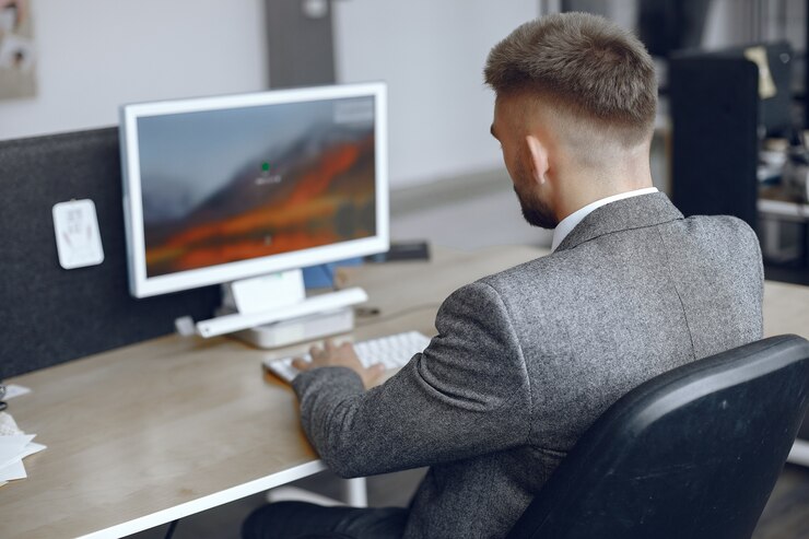 Foto gratuito hombre de negocios que trabaja en la oficina. el hombre usa una computadora. chico está sentado en la oficina