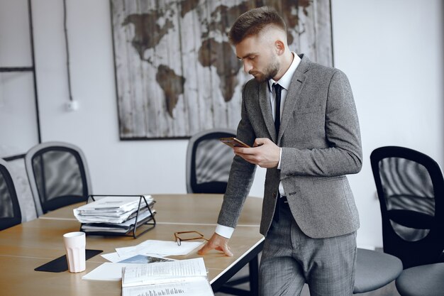 Hombre de negocios que trabaja en la oficina. El hombre usa el teléfono. Chico en traje de negocios