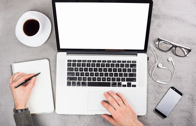 Hombre de negocios que usa la escritura digital de la tableta en el tablero con la pluma sobre el escritorio gris