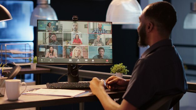 Hombre de negocios reuniéndose con personas en videoconferencia, hablando en videoconferencia remota con conexión a Internet y cámara web. Charlando en una conversación de teleconferencia en línea.