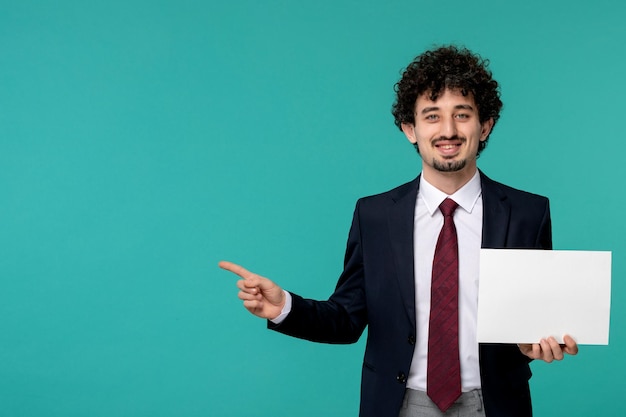 Hombre de negocios rizado lindo chico guapo en traje negro sonriendo y sosteniendo papel