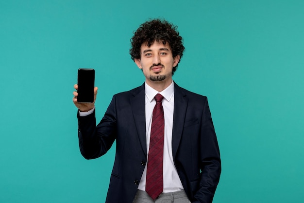 Hombre de negocios rizado lindo chico guapo en traje negro con teléfono