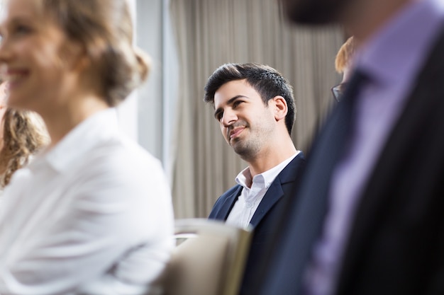 Hombre de negocios sentado entre el público de una conferencia