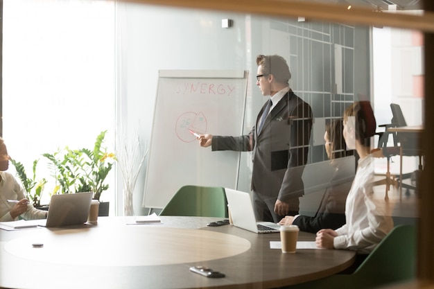 Hombre de negocios serio presentando objetivos de negocio de la empresa a sus colegas