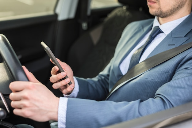 Hombre de negocios con smartphone en coche