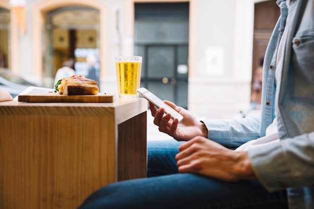 Hombre de negocios con smartphone sentado en el café