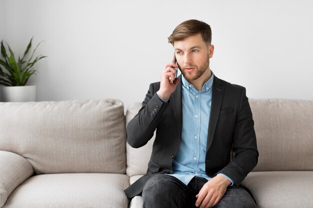 Hombre de negocios en el sofá hablando por teléfono
