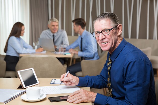 Hombre de negocios sonriente y equipo que trabaja en café