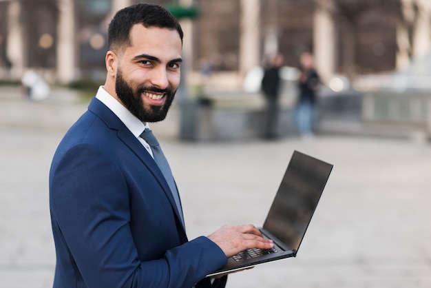 Hombre de negocios sonriente con laptop