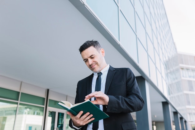 Foto gratuita hombre de negocios sonriente leyendo