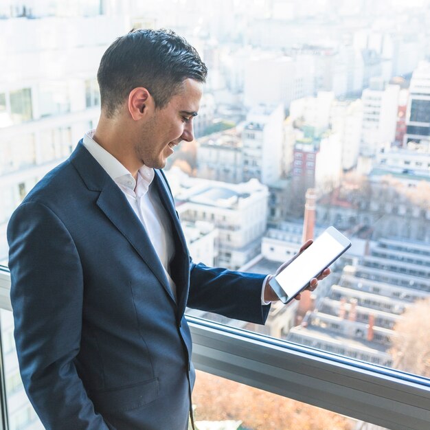 Hombre de negocios sonriente que mira smartphone