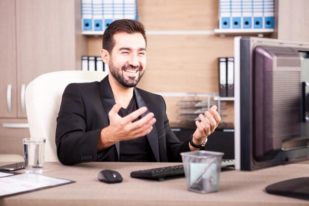 Hombre de negocios sonriente que trabaja en su oficina. Empresario en entorno profesional