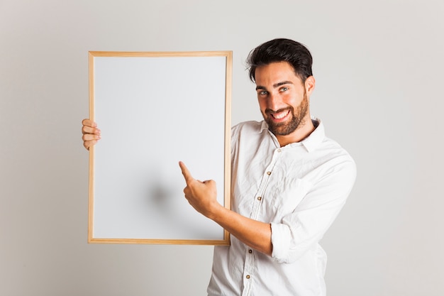 Foto gratuita hombre de negocios sonriente señalando la pizarra blanca