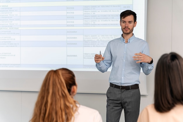 Hombre de negocios sosteniendo una presentación en la oficina para sus colegas