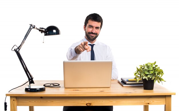 Hombre de negocios en su oficina apuntando hacia el frente