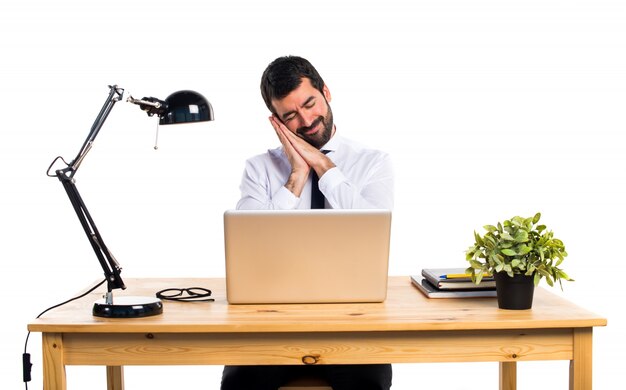 Hombre de negocios en su oficina haciendo gesto de sueño
