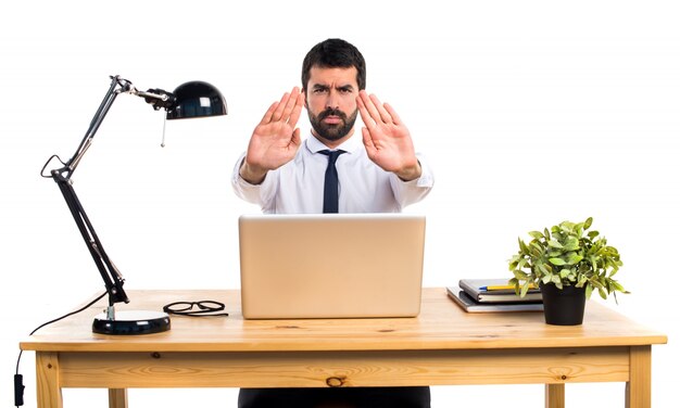 Hombre de negocios en su oficina haciendo señal de stop