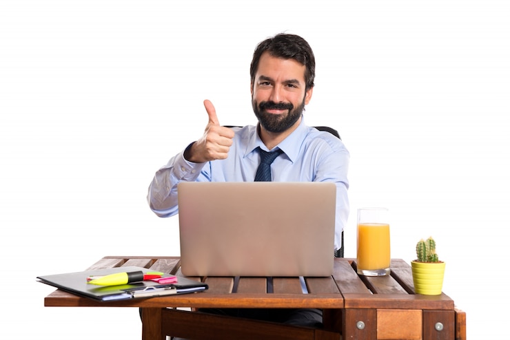 Foto gratuito hombre de negocios en su oficina con el pulgar para arriba