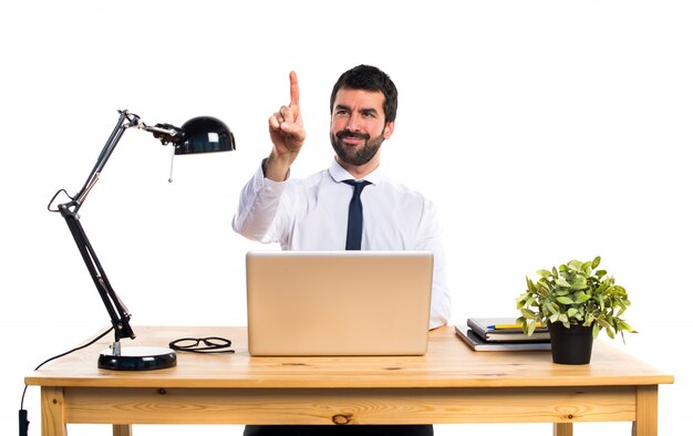 Hombre de negocios en su oficina tocando la pantalla transparente