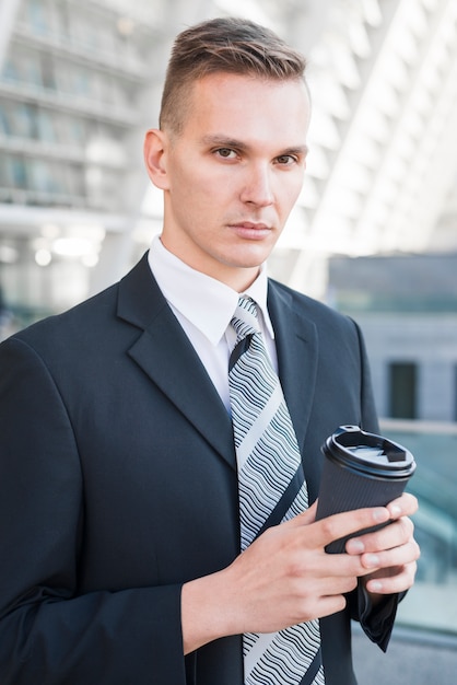 Hombre de negocios sujetando taza de café