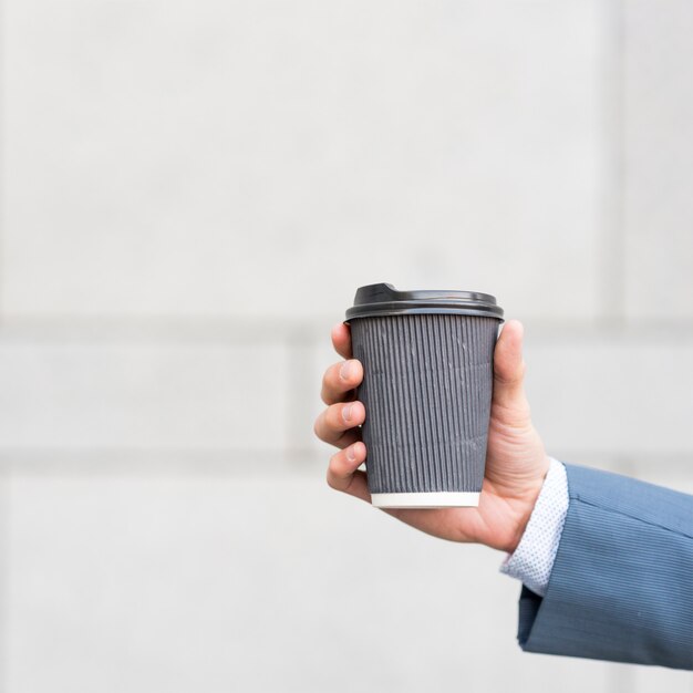 Hombre de negocios sujetando vaso de café
