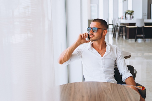 Hombre de negocios con teléfono sentado en la mesa