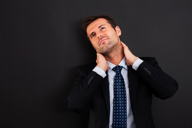 Hombre de negocios, teniendo dolor en el cuello