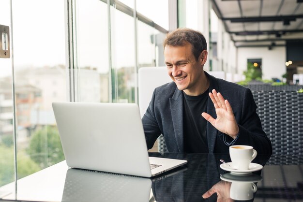 El hombre de negocios tiene una reunión de negocios a través de una videollamada en un café