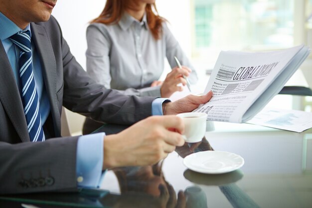 Hombre de negocios tomando un café y leyendo el periódico