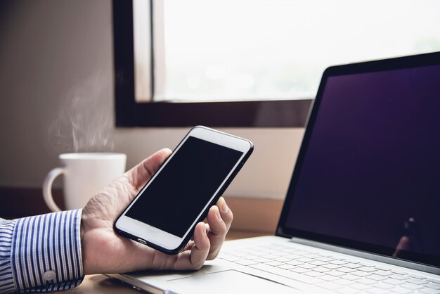 Hombre de negocios trabajando con computadora con taza de café en la habitación del hotel