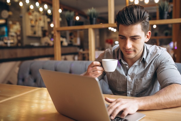 Hombre de negocios trabajando en equipo portátil en un café