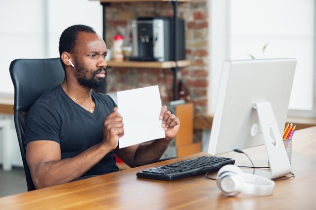 Hombre de negocios trabajando en oficina y sosteniendo carteles en blanco