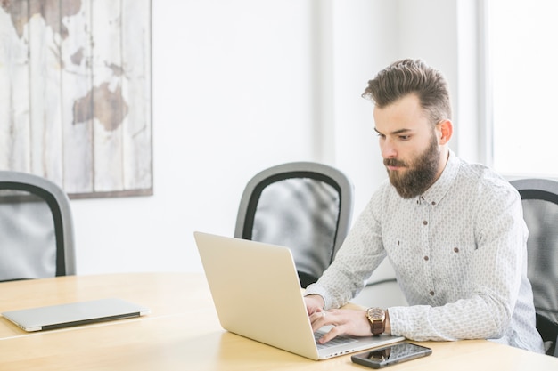 Hombre de negocios trabajando con portátil en oficina