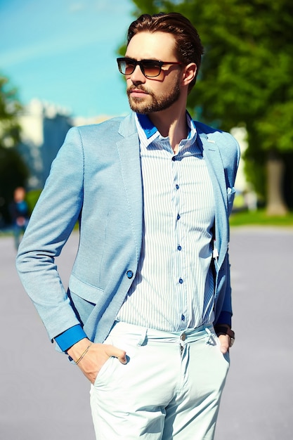 Hombre de negocios en traje azul con gafas de sol en la calle