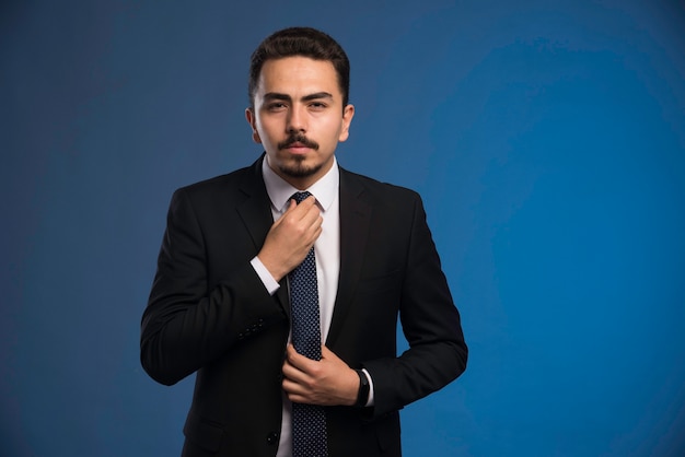 Hombre de negocios en traje negro con corbata.