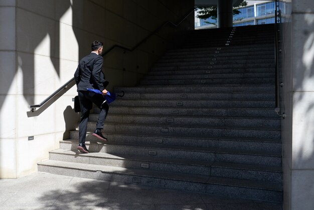 Hombre de negocios en traje subiendo la escalera hacia la entrada de la oficina