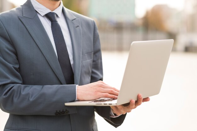 Hombre de negocios usando portátil al aire libre