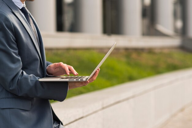 Hombre de negocios usando portátil al aire libre