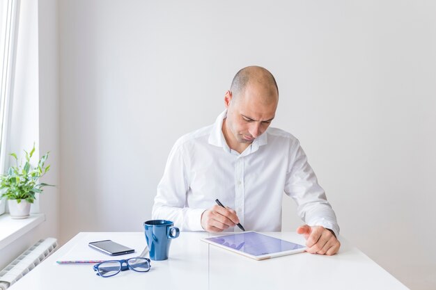 Hombre de negocios usando tableta digital gráfica en el lugar de trabajo