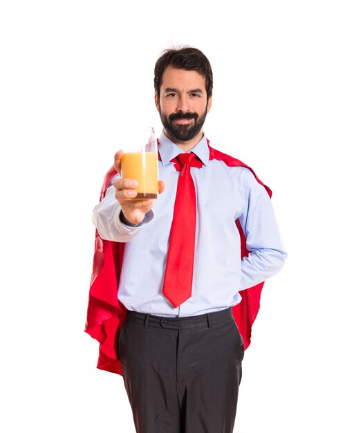 Hombre de negocios vestido como superhéroe con jugo de naranja